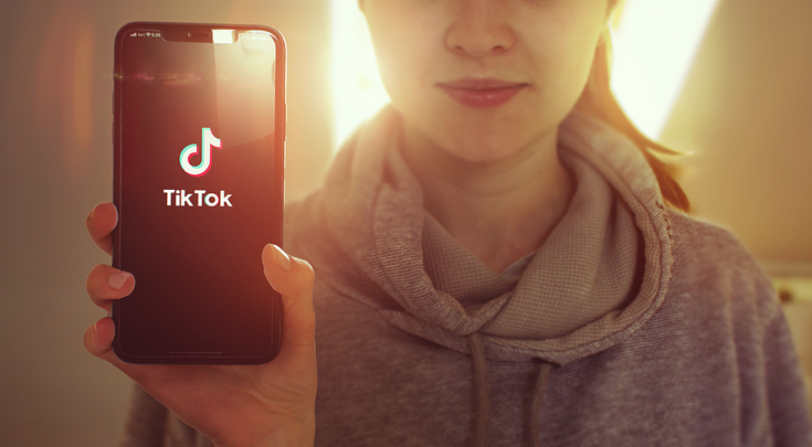 Girl holding mobile with TikTok app